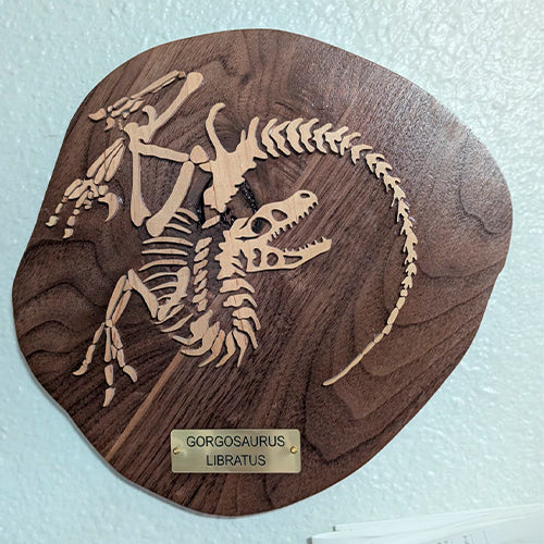Wood carving of a Gorgosaurus fossil in walnut and maple. Handcrafted paleo art for science lovers